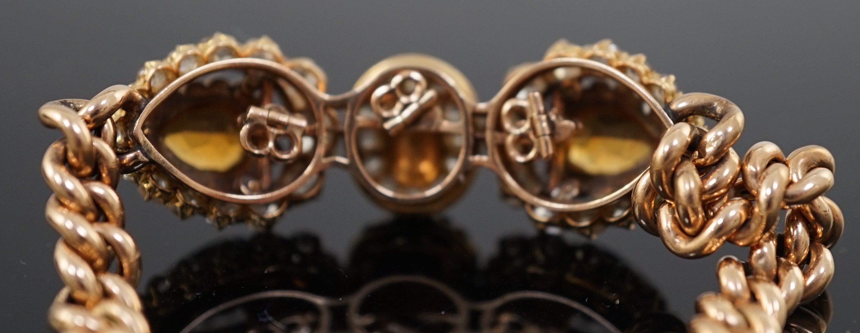 An Edwardian 15ct gold, citrine, turquoise and diamond set triple cluster set curblink bracelet